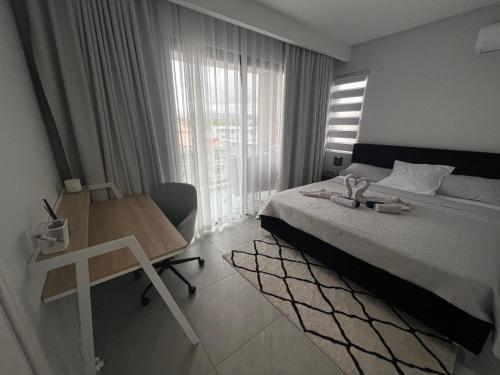 a bedroom with a bed and a desk and a window at Top-Floor Modern 3BD Penthouse with Beautiful Mountain View Terrace - 5 min Walk to Beach in Flic-en-Flac