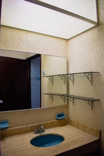 a bathroom with a sink and a large mirror at Suites del Sol Hotel & Apartments in Mérida