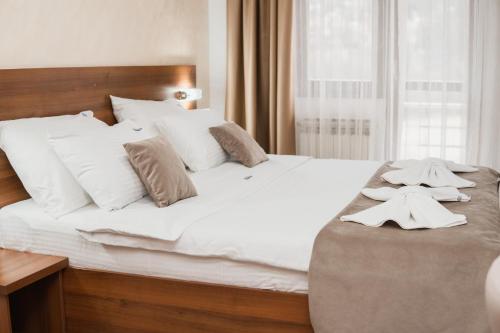 a bedroom with a large white bed with white pillows at Hotel Damis in Pale