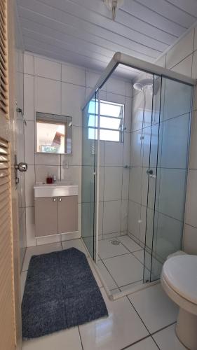 y baño con ducha de cristal y aseo. en Residencial Henrique, en Florianópolis