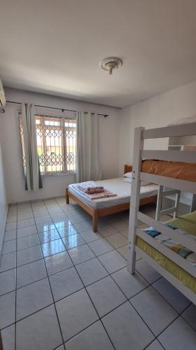 een slaapkamer met een bed en een stapelbed bij Residencial Henrique in Florianópolis