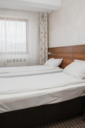 two beds in a bedroom with a window at Hotel Damis in Pale