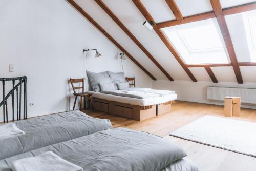 a attic bedroom with two beds and a window at Loftwohnung am Park in Regensburg