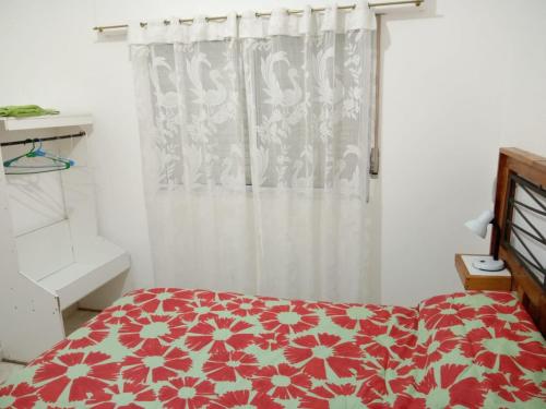 Un dormitorio con una cama roja y blanca y una ventana en Alojamiento Laureant - Capitán Sarmiento - Buenos Aires in 