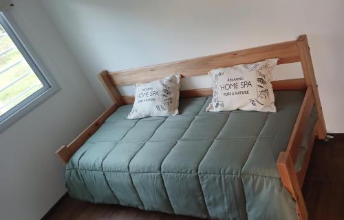 a bed in a tiny room with two pillows at BlackHouse in Federación