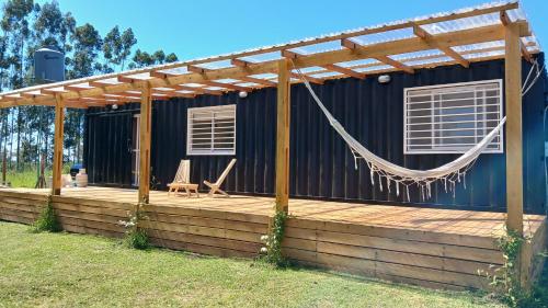 a house with a hammock on a deck at BlackHouse in Federación