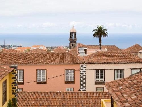 einen Blick auf die Dächer einer Stadt mit einem Uhrturm in der Unterkunft Live Orotava Casa antigua Patrimonio nacional in La Orotava