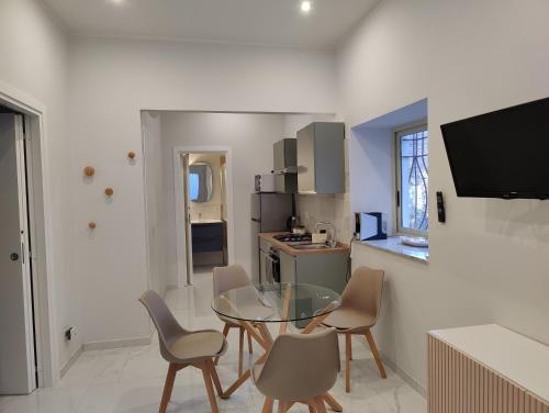 kuchnia ze szklanym stołem i krzesłami w pokoju w obiekcie Cuttigghiu Holiday Apartment w Katanii
