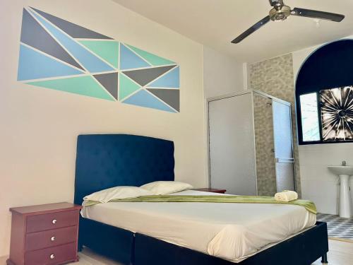 a bedroom with a bed with a blue head board at HOTEL GIRASOL in Carmen de Apicalá