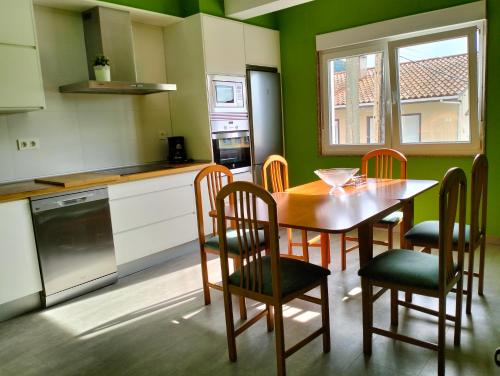 een keuken met een tafel en stoelen in een keuken bij Casa Mallou in San Mamede de Carnota