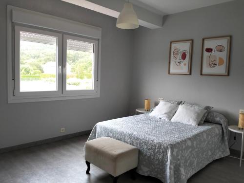 een witte slaapkamer met een bed en een raam bij Casa Mallou in San Mamede de Carnota