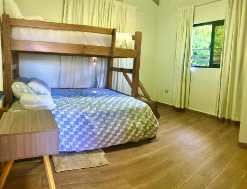 1 dormitorio con litera y suelo de madera en Villa las Mercedes, en Concepción de La Vega