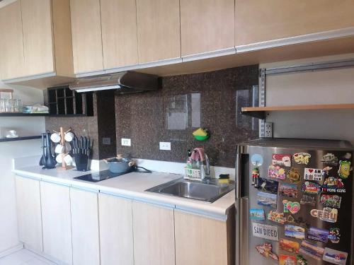 a kitchen with a sink and a refrigerator with magnets at Roxas Blvd Stunning Studio Condo Near US Embassy in Manila