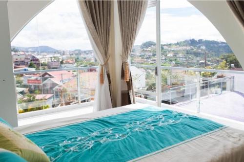 a bed in a room with a large window at Da Lat LUCINA Boutique Hotel in Da Lat