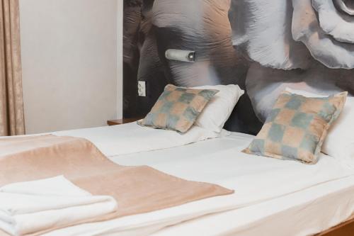a bedroom with two beds and a painting of an elephant at Hotel Damis in Pale