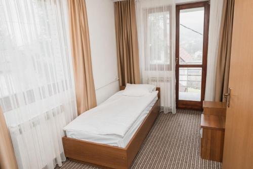 a small bed in a room with a window at Hotel Damis in Pale