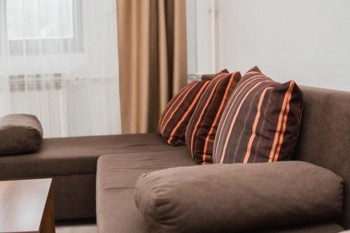 a couch with three pillows on it in a living room at Hotel Damis in Pale