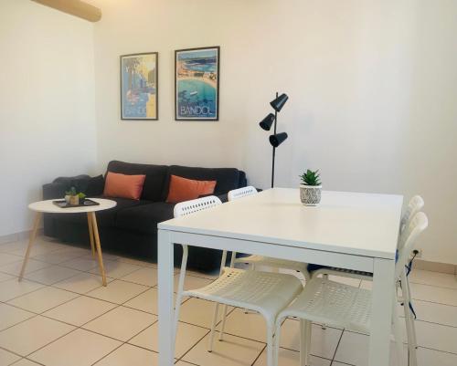 un salon avec une table et des chaises blanches dans l'établissement Studio climatisé hypercentre Bandol et Plages, à Bandol