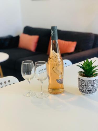 une bouteille de vin et deux verres à vin sur une table dans l'établissement Studio climatisé hypercentre Bandol et Plages, à Bandol