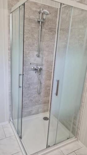 a shower with a glass enclosure in a bathroom at Maison Retour vers le Futur - 2 chambres / jardin in Marmagne