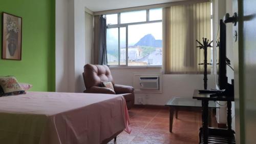 a room with a chair and a window with a window at Apartamento na Praia de Copacabana in Rio de Janeiro