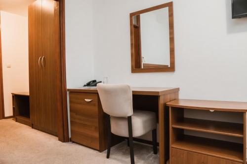 a room with a desk with a chair and a mirror at Hotel Damis in Pale