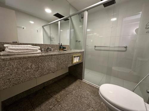 uma casa de banho com um chuveiro, um WC e um lavatório. em Kubitschek Plaza Hotel - Flat Particular 2 em Brasília