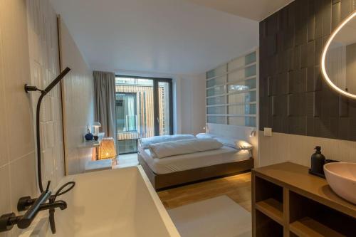 bagno con letto, vasca e lavandino di Kleines Stadthaus in Toplage a Vienna