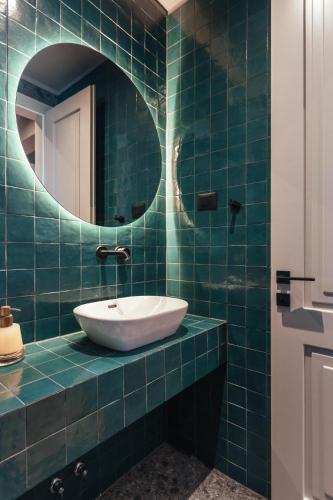 a blue tiled bathroom with a sink and a mirror at Villa Val & Sol in Dubrovnik
