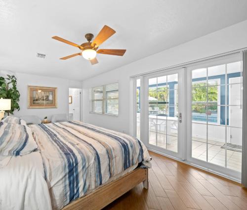een slaapkamer met een bed en een plafondventilator bij Skipper's Landing - 4 Bedroom with Heated Pool in Cocoa Beach