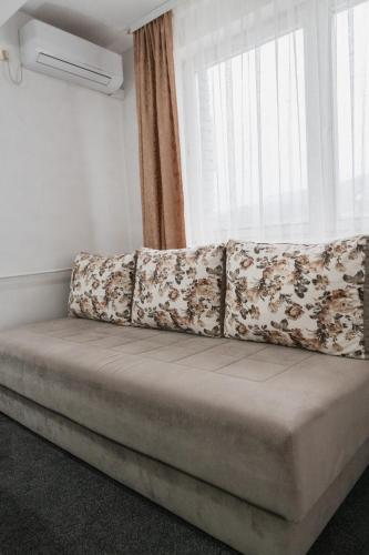 a couch sitting in a room with a window at Hotel Damis in Pale