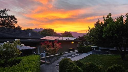 a house with a sunset in the background at Perfect Country Home in Tawonga