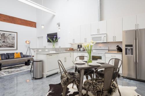 a kitchen with white cabinets and a table with chairs at Petaluma Warehouse Lofts Unit C in Petaluma