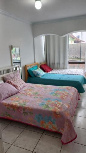 two beds sitting next to each other in a bedroom at Cozinha Equipada em Apartamento para Alugar em Torres RS in Torres