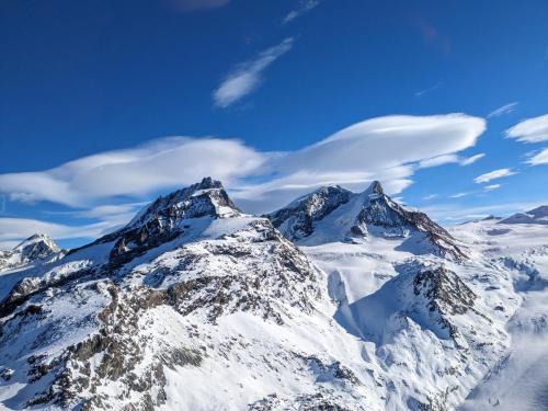 a mountain covered in snow with a blue sky at Zermattmountainchalet Tambiel in Zermatt