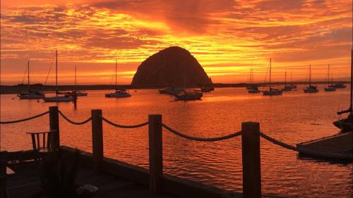 einen Sonnenuntergang über einem Hafen mit Booten im Wasser in der Unterkunft Anderson Inn in Morro Bay