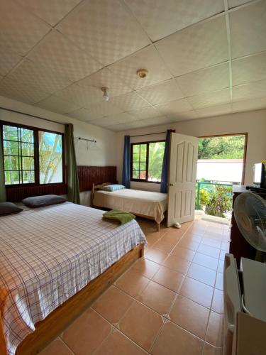 a bedroom with a bed and two windows at Rainforest Yasmin Hotel in Santa Fe