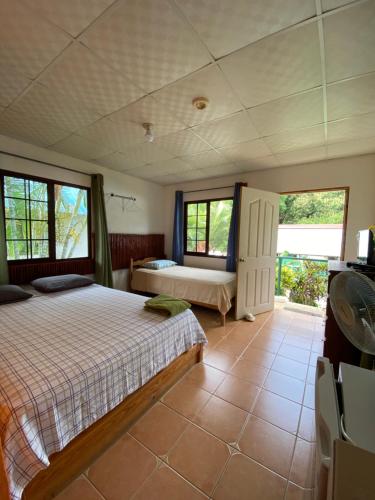 a bedroom with a bed and two windows at Rainforest Yasmin Hotel in Santa Fé