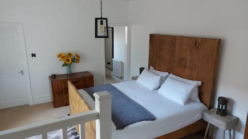 a bedroom with a large bed with a wooden headboard at Superking Size City Centre En-Suite Room + Parking in Preston