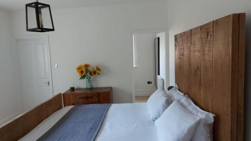 a bedroom with a large bed with a wooden headboard at Superking Size City Centre En-Suite Room + Parking in Preston