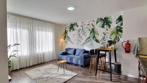 a living room with a blue couch and a plant mural at King Bed 4 people near Basel, Switzerland, Weil am Rhein, Loerrach, Germ'any, Near Airport in Saint-Louis