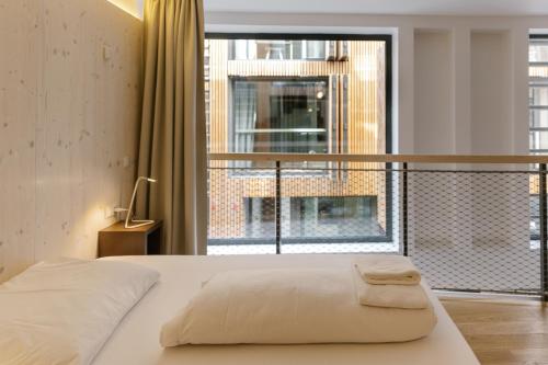 a bedroom with a bed and a large window at Kleines Stadthaus in Toplage in Vienna
