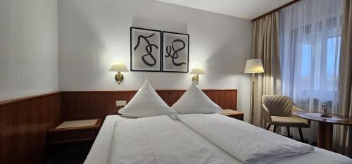 una camera d'albergo con letto, scrivania e finestra di Hotel Garni Vierjahreszeiten a Bad Staffelstein