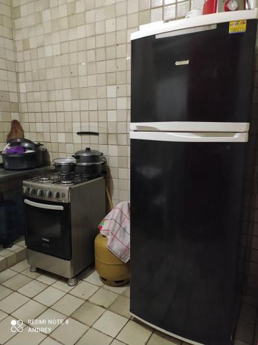 cocina con fogones y nevera negra en Marbelo Pernambuco Hostel, en Recife