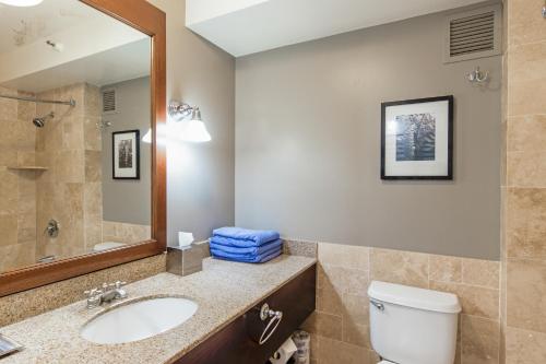 a bathroom with a sink and a toilet and a mirror at Kauai Beach Resort Room 2401 in Lihue