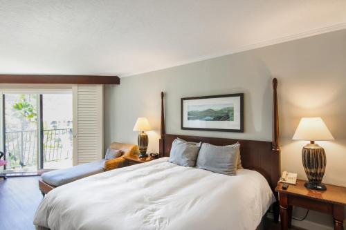 a bedroom with a large white bed with two lamps at Kauai Beach Resort Room 2401 in Lihue