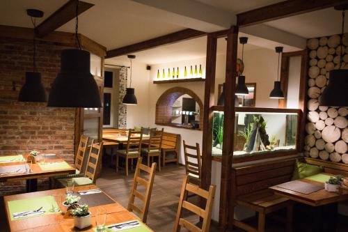 a restaurant with tables and chairs and a fish tank at Penzion La Piccolina in Nový Bor