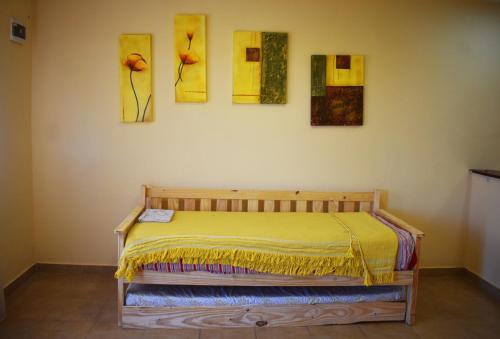 帕索德洛斯利布雷斯的住宿－Nuevo Departamento Leona - EXCELENTE PROPIEDAD A ESTRENAR，墙上有四幅画作的房间的一张床位
