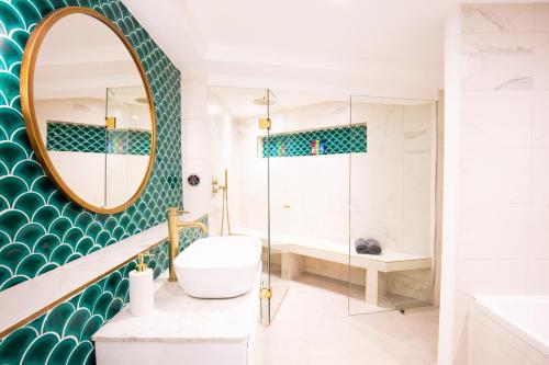 a bathroom with a tub and a sink and a mirror at Hidden Retreat with Steam room, KING bed near tube in London