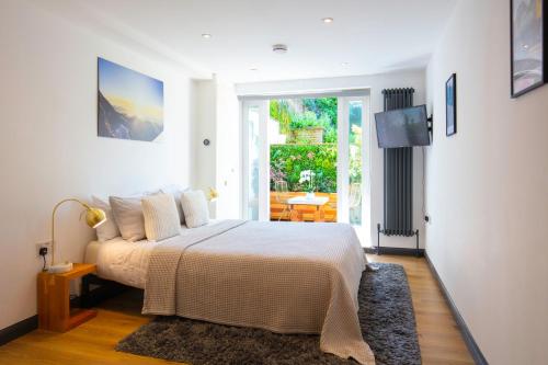 a bedroom with a bed and a sliding glass door at Hidden Retreat with Steam room, KING bed near tube in London